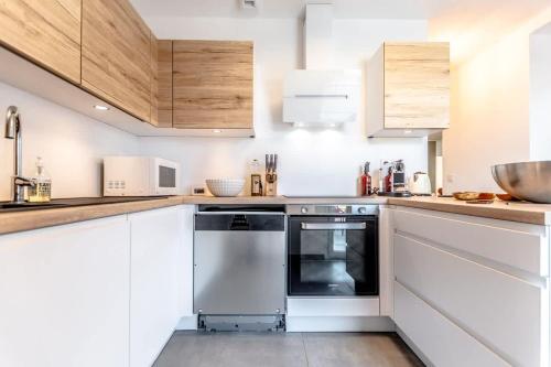 La cuisine est équipée de placards blancs et d'un lave-vaisselle. dans l'établissement Villa Les Mures l Pool & Garden l Shellter Rentals, à Grimaud