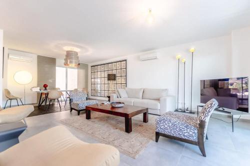 un salon avec un canapé et une table dans l'établissement Villa Les Mures l Pool & Garden l Shellter Rentals, à Grimaud