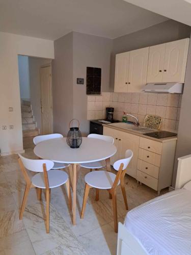 a kitchen with a table and chairs and a kitchen with a sink at Modern apartment in Paleo Tsifliki