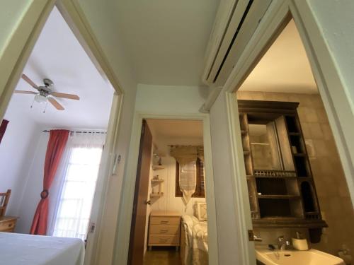 a bedroom with a ceiling fan and a mirror at TH31 Casa adosada con piscina y playa al lado in Torredembarra