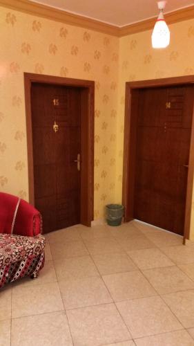 a room with two doors and a tiled floor at Bahget Eljouf Furnished Apartment in Sakakah