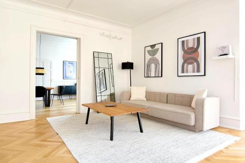 Una sala de estar con un sofá y una mesa de café. en Huge modern & central 2BR loft, en Copenhague