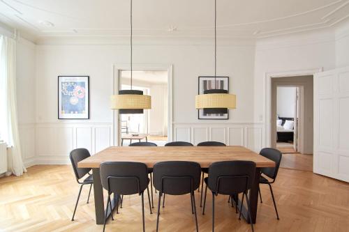 Un comedor con mesa y sillas de madera. en Huge modern & central 2BR loft, en Copenhague