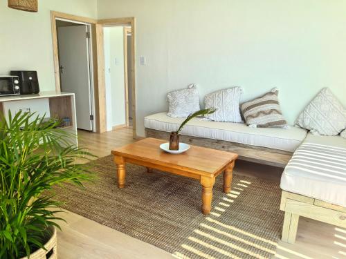 a living room with a couch and a coffee table at Secret Sunrise in Jeffreys Bay
