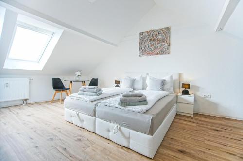 biała sypialnia z dużym białym łóżkiem i oknem w obiekcie AusZeit Steiraland 2 mit privaten Terrasse und Garten und Parkplatz w mieście Nennersdorf