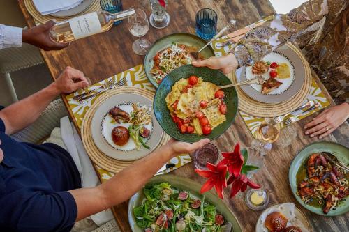 a group of people sitting at a table with plates of food at La Residence in Franschhoek