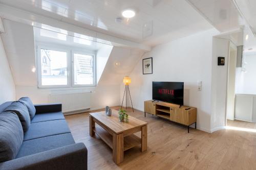 a living room with a blue couch and a tv at Vulkaneifel Cottage in Kottenheim