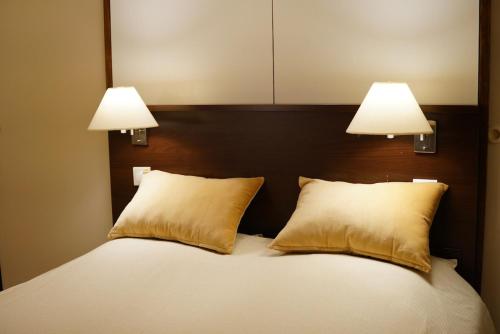 - un lit avec 2 oreillers et 2 lumières au-dessus dans l'établissement Charming comfortable studio, heart of Vauban 533, à Lille