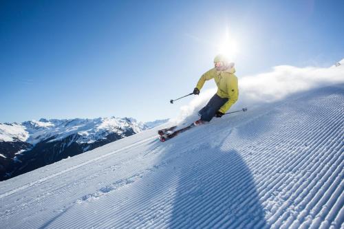 a person is skiing down a snow covered slope at Explorer Hotel Berchtesgaden in Schönau am Königssee