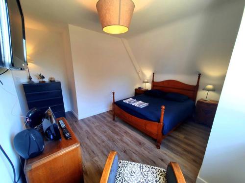 une chambre avec un lit et une commode dans l'établissement Le pré Colas- la maison néo bretonne, à Pordic