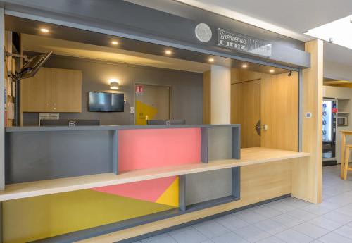 a lobby with a colorful counter in a store at B&B HOTEL Marne-la-Vallée Bussy-Saint-Georges in Bussy-Saint-Georges