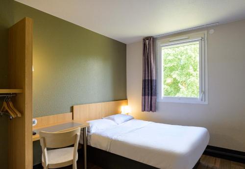 a bedroom with a bed and a desk and a window at B&B HOTEL Marne-la-Vallée Bussy-Saint-Georges in Bussy-Saint-Georges