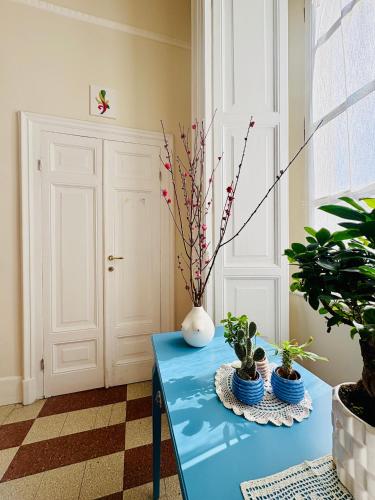 a blue table with a vase and some plants on it at Voglia 'e turnà in Naples