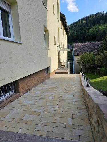 a building with a brick walkway in front of it at Miuti Residence in Triberg