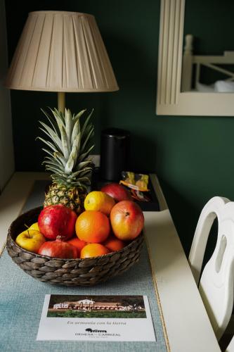 a basket of fruit on a table with a lamp at Hospedium Nuevo Hotel Parque Cabaneros in Horcajo de los Montes