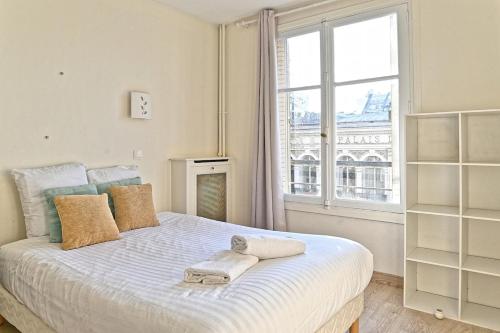 une chambre avec un lit avec une grande fenêtre dans l'établissement Appartement Central Avenue du Maine - III, à Paris