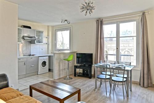 une cuisine et un salon avec une table et des chaises dans l'établissement Appartement Central Avenue du Maine - III, à Paris