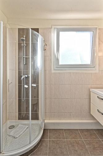 La salle de bains est pourvue d'une douche et d'une fenêtre. dans l'établissement Appartement Central Avenue du Maine - III, à Paris