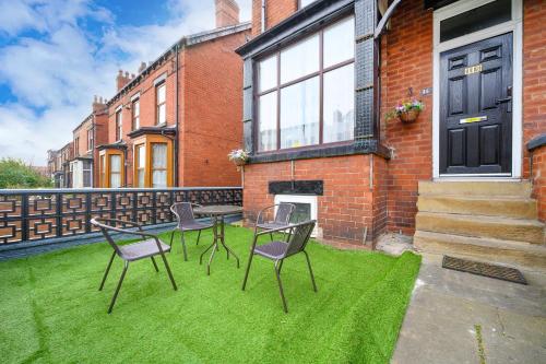 a patio with chairs and a table on the grass at -RA15CFA- For Relaxed and Cosy stay with Free Parking in Leeds