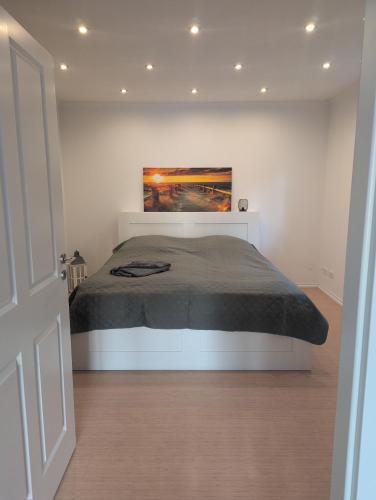 a bedroom with a bed with a painting on the wall at Ferienwohnung Brückenblick 85112 in Ostrhauderfehn