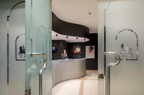 a woman is sitting at a counter in a room at Hotel Marc'Aurelio in Rome