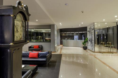 a living room with a couch and a clock at Hotel Marc'Aurelio in Rome