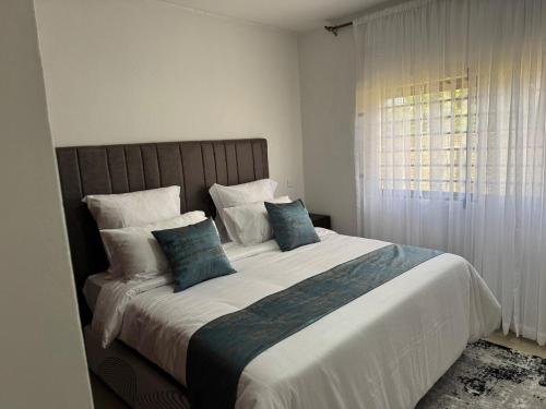 una camera da letto con un letto grande con cuscini blu di Kachimam Apartment a Lusaka