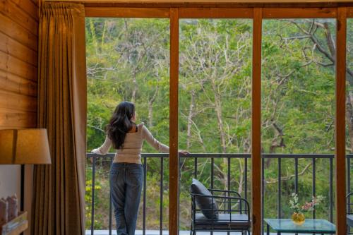 a woman standing on a balcony looking out the window at Perfectstayz The Silhouette in Shivpuri