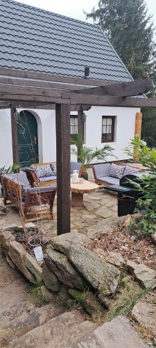 a house with a porch with a couch and a table at Dom Gościnny Zarembianka in Międzylesie