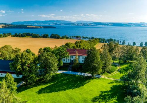 an aerial view of a house with a lake in the background at Hoel Gård - Herregården ved Mjøsa in Nes i Ådal