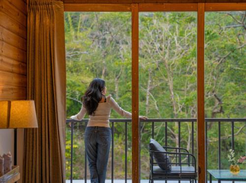a woman standing on a balcony looking out the window at Perfectstayz The Silhouette in Shivpuri