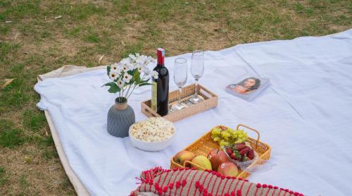 a picnic table with a bottle of wine and a basket of fruit at Perfectstayz The Silhouette in Shivpuri