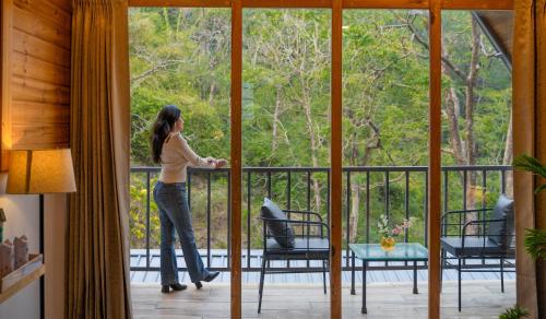 a woman standing on a balcony looking out the window at Perfectstayz The Silhouette in Shivpuri