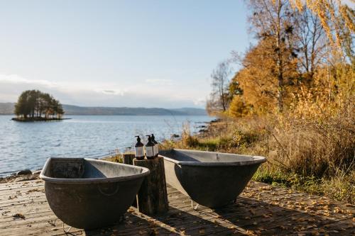 a bath tub sitting next to a body of water at Hoel Gård - Herregården ved Mjøsa in Nes i Ådal