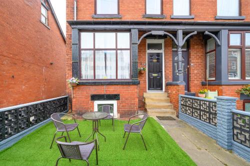 a patio with chairs and a table on the grass at -RB15CFA- For Relaxed and Cosy stay with Free Parking in Leeds