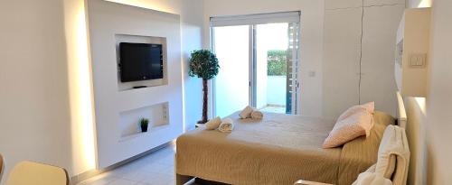 a room with a bed with a tv on a wall at Peixe and Barco Studio's in Vilamoura