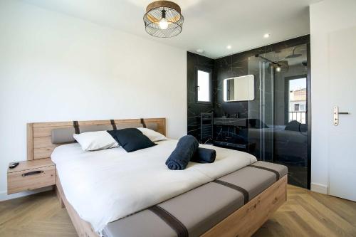 - une chambre avec un grand lit et une douche en verre dans l'établissement La Villa Infinity, à Villeneuve-Loubet