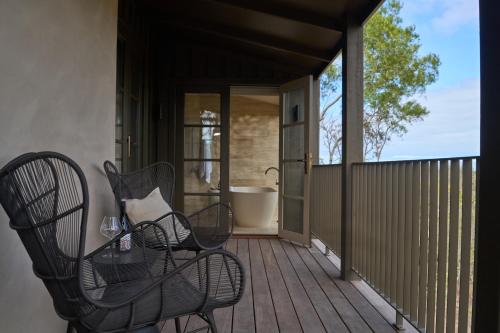 a porch with chairs and a tub on a deck at The Sanctuary at Alba Thermal Springs & Spa in Fingal