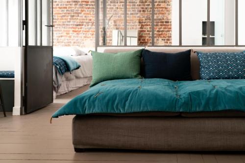 - un canapé avec des oreillers dans l'établissement Charming studio in Montmartre near Sacre Cœur, à Paris