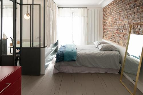 une chambre avec un lit et un mur de briques dans l'établissement Charming studio in Montmartre near Sacre Cœur, à Paris