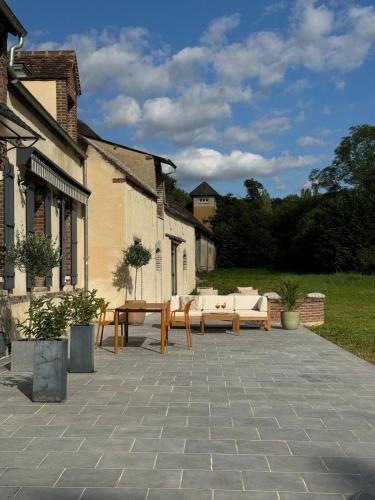 d'une terrasse avec des canapés et une table dans la cour. dans l'établissement La Maison de Passy, à Passy