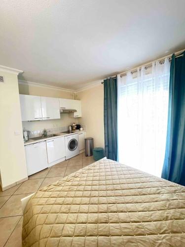 une chambre avec un grand lit et une cuisine dans l'établissement Jolie studio à Cannes, à Cannes