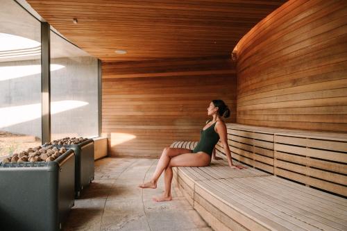 a woman is sitting in a sauna at The Sanctuary at Alba Thermal Springs & Spa in Fingal