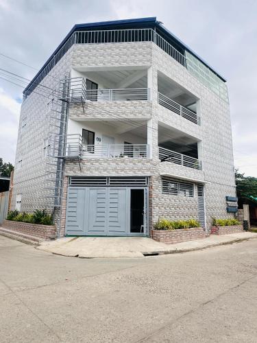 a large brick building with a garage at DVM Transient Inn in Santo Tomas