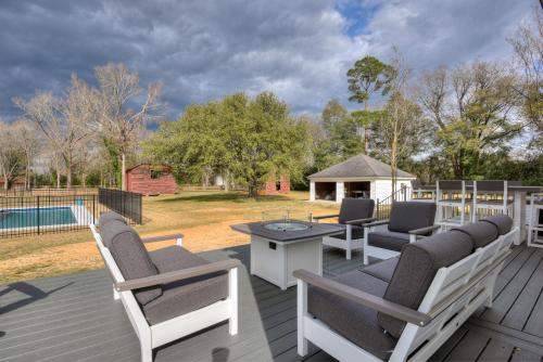 a deck with chairs and a table and a pool at Burrell and Flynn's Farm in Aiken