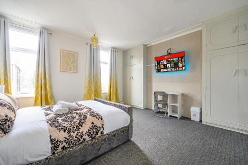 Un dormitorio con una cama y un televisor en la pared. en -RC15CFA- For Relaxed and Cosy stay with Free Parking, en Leeds