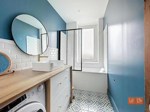 La salle de bains est pourvue d'un lave-linge et d'un miroir. dans l'établissement Wimereux - Appartement 2 chambres proche mer et centre, à Wimereux