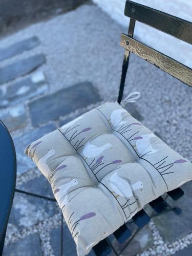 a seat of a park bench with a pillow on it at Jemima Barn in Holsworthy