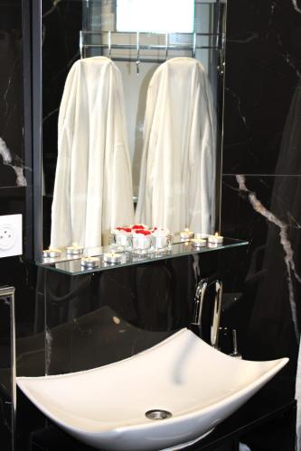 La salle de bains est pourvue d'un lavabo et d'un miroir. dans l'établissement Suite Neptune Jaccuzi, à Pont-Saint-Esprit