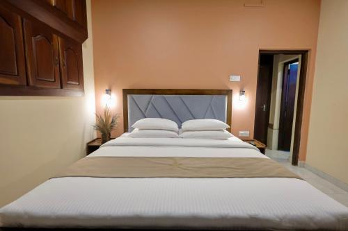 a large bed with white pillows in a bedroom at Limeshine Residence - Airport Transit Hotel in Katunayake